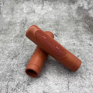 Close-up detail of brown rubber bicycle handlebar grips showing concentric anti-slip patterns.