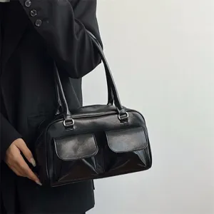 Detailed view of the stylish black glossy PU leather shoulder bag featuring front pockets.