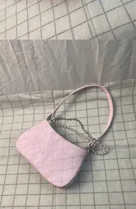 Chic pink quilted underarm bag with elegant pearl and metal chain, stylish shoulder handbag.