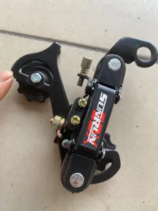 Detalle de desviador trasero de bicicleta, cambio negro de metal con tornillos.