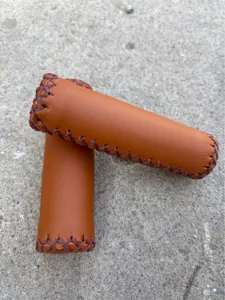 Detail view of brown PU leather bicycle handlebar grips with retro cross stitching design.