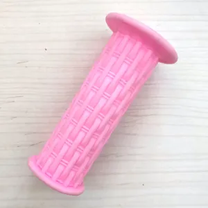 Pink woven kids bike handlebar grip detail, soft rubber bicycle accessory close up view.
