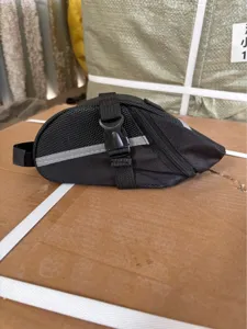 Primo piano dettagliato della borsa sottosella per bicicletta nera con striscia riflettente.