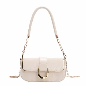 Élégant sac à bandoulière matelassé pour femme avec chaîne chic et boucle dorée.
