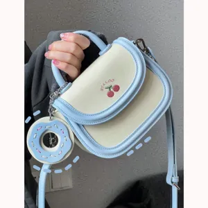 Piccola borsa a sella crema azzurro con grazioso ciondolo a ciambella, borsa a tracolla casual.