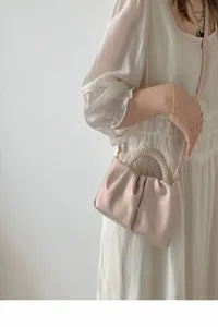 Detail shot of the pleated cloud handbag featuring an elegant pearl handle and soft PU leather.