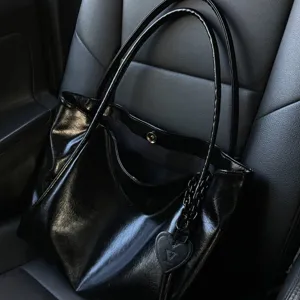Black large capacity tote bag with heart charm, lightweight commuter shoulder bag detail view.