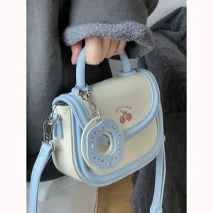 Piccola borsa a tracolla con tracolla regolabile e ciondolo a ciambella per uso quotidiano.