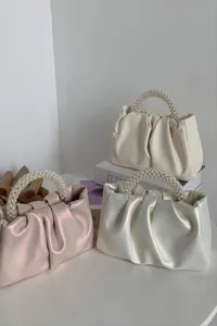 Stylish ruched cloud handbag featuring elegant pearl beaded handle, chic women mini bag.