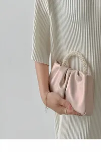 Chic pleated satin mini handbag with elegant pearl handle, perfect stylish cloud bag detail.