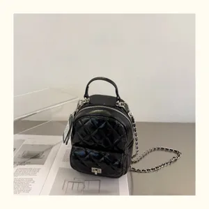 Mini sac à dos matelassé noir en cuir avec bandoulière chaîne et poignée pour femme élégante.