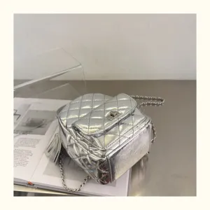 Vue détaillée du mini sac à dos matelassé argenté avec texture métallique et bandoulière chaîne.