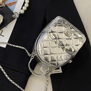 Mini sac à dos matelassé argenté pour femme, bandoulière chaîne et sac de voyage chic.
