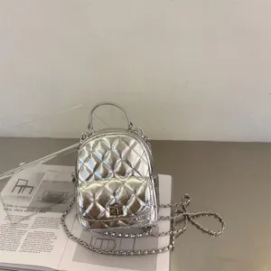 Mini sac à dos matelassé métallisé argenté avec bretelles chaîne et fermoir avant.