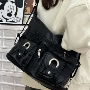 Black faux leather shoulder bag with multiple front pockets and metal ring buckles for women.