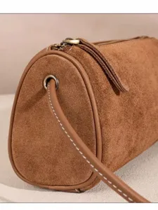 Brown suede cylindrical crossbody bag, stylish women's shoulder bag with zipper and strap.
