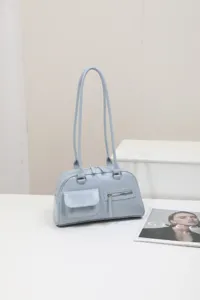 Chic light blue shoulder bag for women, retro minimalist design with front pockets for daily commute.