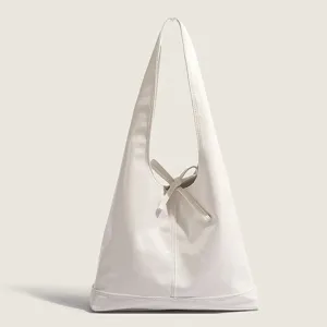 White soft leather hobo shoulder bag detail showing elegant bow tie and vertical seam design.
