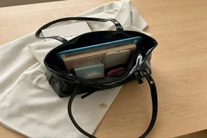 Black glossy tote shoulder bag for women, large capacity commuter casual bag for daily use.