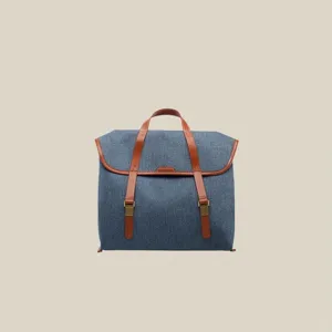 Detailaufnahme des Freizeitreisenden Denim Canvas Rucksacks mit braunen Ledergurten.