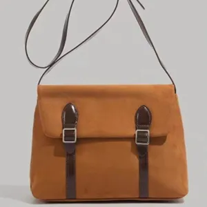Detailed view of the brown vintage suede messenger bag with stylish dual buckle straps.