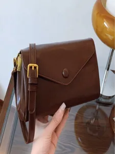 Retro brown leather shoulder bag for women, elegant envelope crossbody bag with gold hardware.