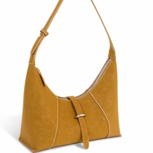Close-up of vintage brown suede hobo bag featuring contrast white stitching and front buckle.