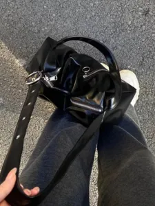Vue détaillée du sac cabas Y2K en cuir souple noir brillant avec texture et accessoires.