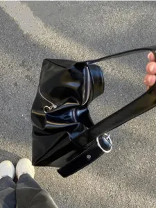 Gros plan du sac porté épaule Y2K en cuir souple noir avec fermeture éclair et anneau.