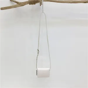 Minimalist white mini crossbody bag detail shot, showing cute compact design and fine strap.