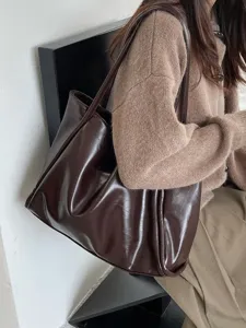 Detailed view of a stylish dark brown soft PU leather slouchy shoulder tote bag in daily scene.