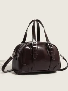 Detailed view of the dark brown retro pillow bag, showing the metal buckle and texture.