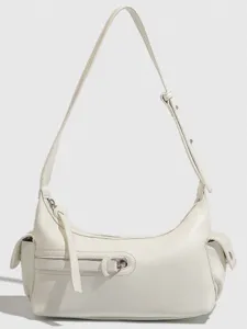 White crescent underarm shoulder bag with side pockets, front zipper detail and strap.