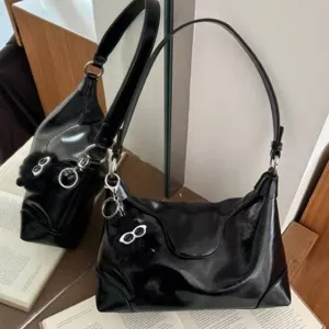 Black patent leather hobo shoulder bag with chic dumpling design and stylish charm.