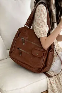 Vintage brown leather shoulder bag detail, large capacity travel tote with multiple zippers.