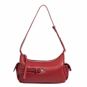 Red leather shoulder bag with white contrast stitching and chic crescent hobo design.