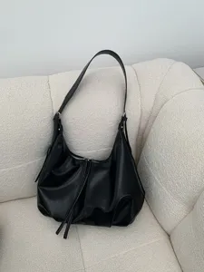 Vista di dettaglio della borsa a tracolla retrò nera, con texture elegante e design con zip.