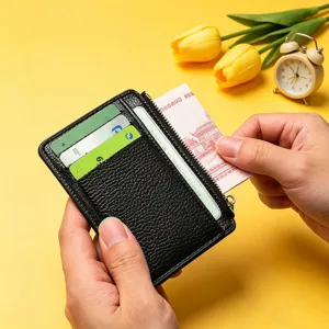 Primo piano del porta carte nero con motivo litchi, scomparti multipli e tasca con zip.