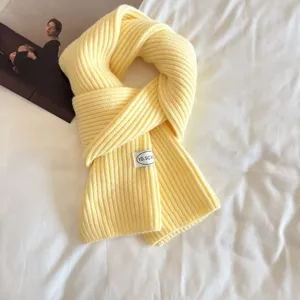 Close-up detail of yellow ribbed knit scarf, cozy winter texture and soft warm fabric.