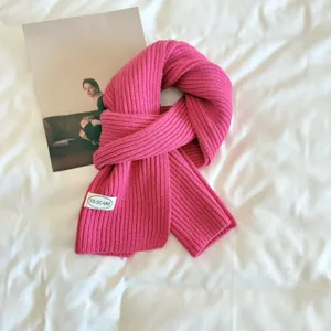Detailed view of a vibrant pink knit scarf, soft warm winter accessory, minimalist texture.