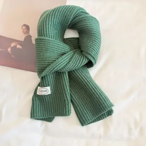 Green ribbed knitted scarf detail, winter warm woolen neck warmer, cozy soft fabric accessory.