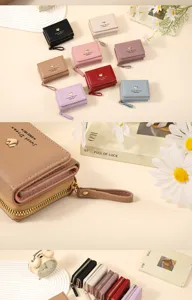 Close up of multi color short women wallet with cute heart charm and wrist strap detail.