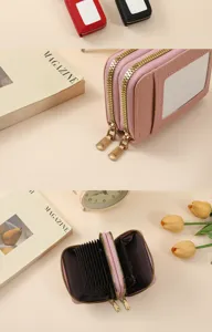 Pink accordion card wallet detail shot showing multi-slot layout and smooth metal zippers.