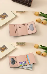 Women's pink trifold wallet with multiple card slots and heart ID window, stylish design.