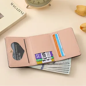 Pink trifold women's wallet with heart ID window, multiple card slots and cash compartment.