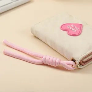 Short tri-fold wallet for women with cute pink heart patch and matching lanyard strap.