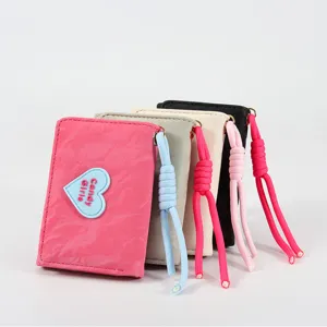 Short tri-fold wallet with heart patch and wrist strap, compact stylish multi-color purse.