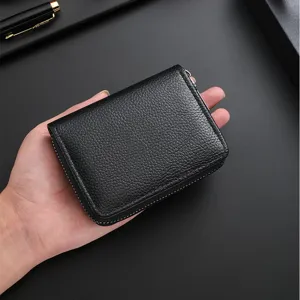 Black leather short zipper wallet held in hand, classic pebbled texture coin purse for daily use.
