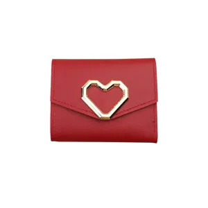 Red short trifold wallet for women with elegant gold heart clasp, compact card holder.