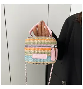 Detailansicht der bunten Stroh Korbtasche mit farbigen Streifen und einer feinen Kette.